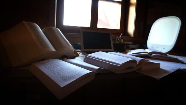 Lehrbücher und Unterlagen liegen auf dem Schreibtisch eines Studenten. Lehrbücher und Unterlagen liegen auf dem Schreibtisch eines Studenten.