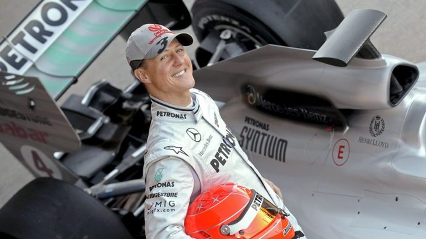 Der deutsche Formel-1-Pilot Michael Schumacher posiert 2010 neben seinem Mercedes-Rennwagen.