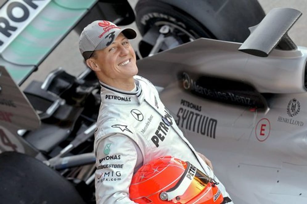 Der deutsche Formel-1-Pilot Michael Schumacher posiert 2010 neben seinem Mercedes-Rennwagen.