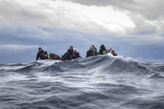 Männer aus Marokko und Bangladesch in einem überfüllten Holzboot vor der Küste von Libyen.