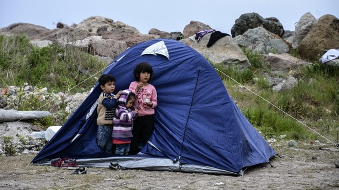 Kinder stehen vor einem Zelt im Dorf Petra auf der Ägäisinsel Lesbos.