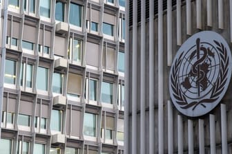 Das Logo und das Gebäude des Hauptsitzes der Weltgesundheitsorganisation (WHO) in Genf.
