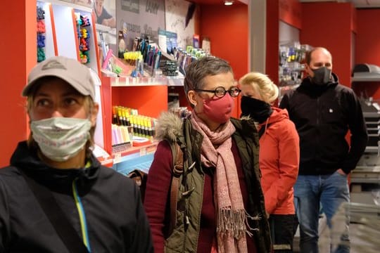 Kunden warten in einem Schreibwarengeschäft in Leipzig.