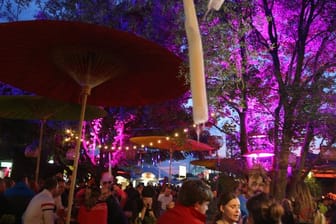 Menschen stehen bei dem Tollwood Festival in München an einer beleuchteten Bar (Archivbild): Die meisten Angebote werden nichts kosten.