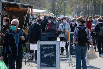 Besucher tragen auf dem Wochenmarkt in der Innenstadt von Dresden Schutzmasken.