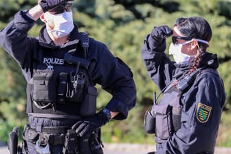 Polizisten mit Mundschutz überwachen eine Kundgebung der rechtsextremen Vereinigung Pro Chemnitz vor dem Karl-Marx-Monument: Die Kundgebung fand unter strengen Auflagen statt.