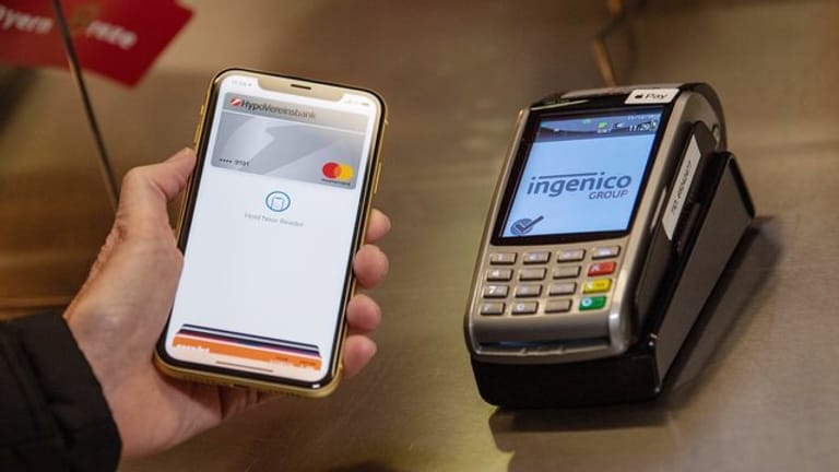 Ein Nutzer zahlt per Smartphone (Symbolbild): Kontaktloses Bezahlen mit Apple Pay unterstützen jetzt auch Deutschlands Volksbanken.