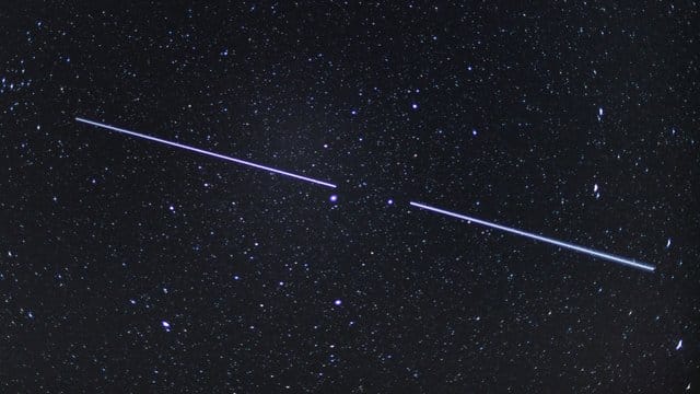 Zwei "Starlink"-Satelliten sind als Lichtstreifen am Nachthimmel zu sehen.