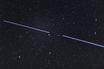 Zwei "Starlink"-Satelliten sind als Lichtstreifen am Nachthimmel zu sehen.