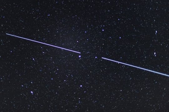 Zwei "Starlink"-Satelliten sind als Lichtstreifen am Nachthimmel zu sehen.