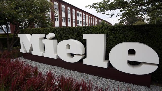 Das Logo "Miele" vor dem Hauptsitz der Miele & Cie KG: In einem Werk der Firma haben sich mehrere Mitarbeiter mit dem Coronavirus infiziert.