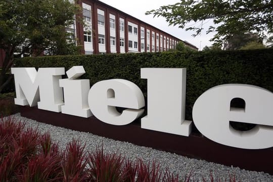 Das Logo "Miele" vor dem Hauptsitz der Miele & Cie KG: In einem Werk der Firma haben sich mehrere Mitarbeiter mit dem Coronavirus infiziert.