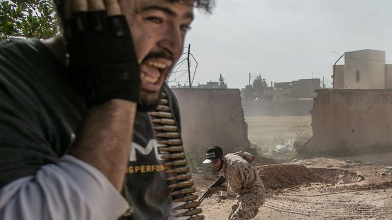 Kämpfer der Regierung gehen bei Zusammenstößen mit den Truppen der Libysch-Nationalen Armee in Deckung.