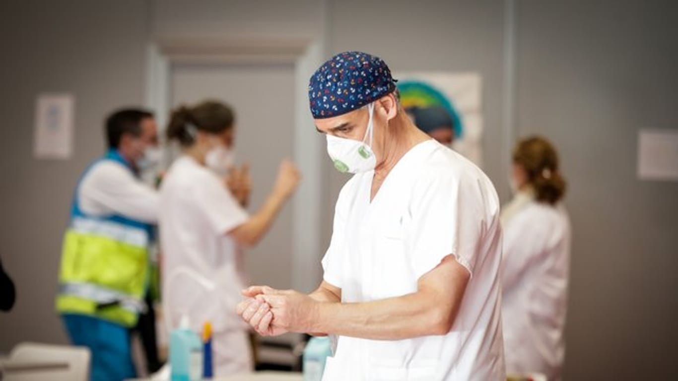 Ein Mitarbeiter des spanischen Gesundheitswesens desinfiziert seine Hände.