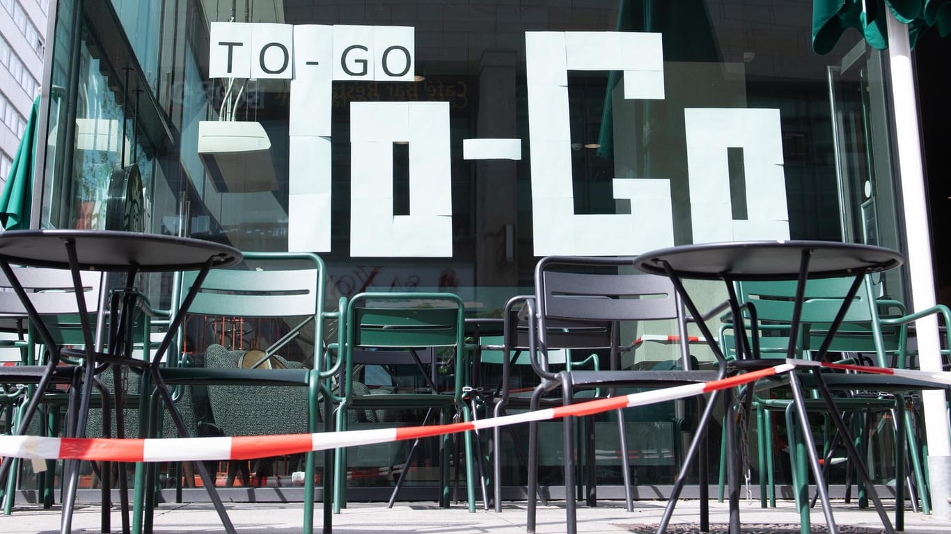 Weiße Blätter kleben in dem Fenster eines Kaffees und bilden den Schriftzug "To-Go": Außer-Haus-Lieferungen und Take-away-Angebote sind weiter erlaubt.