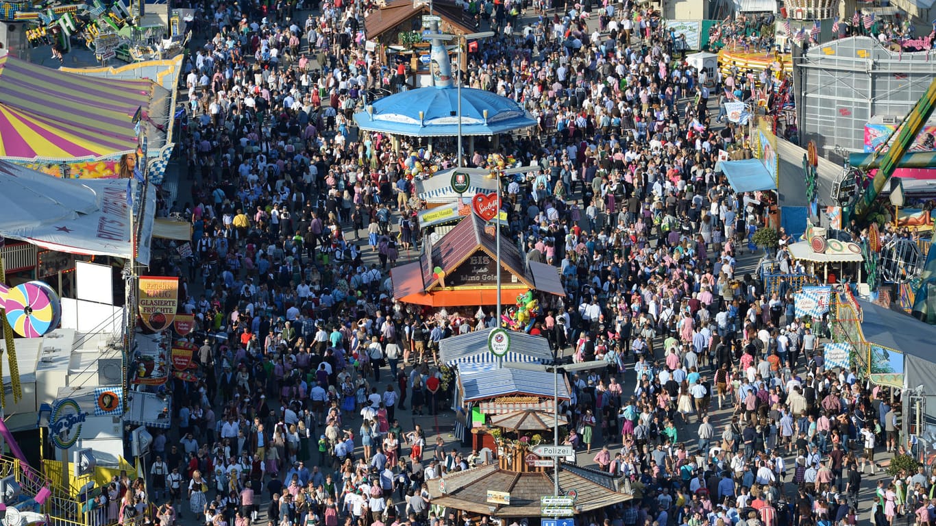 Zahlreiche Menschen gehen bei Sonnenschein über das Oktoberfest-Gelände in München (Archivbild): In diesem Jahr fällt das größte Volksfest der Welt aus.