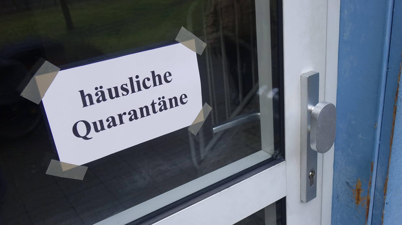 An einer Haustür hängt ein Schild mit "häuslicher Quarantäne" (Symbolbild): In Hagen haben zwei Bewohner eines Quarantäne-Hauses das Gebäude über eine Leiter verlassen.