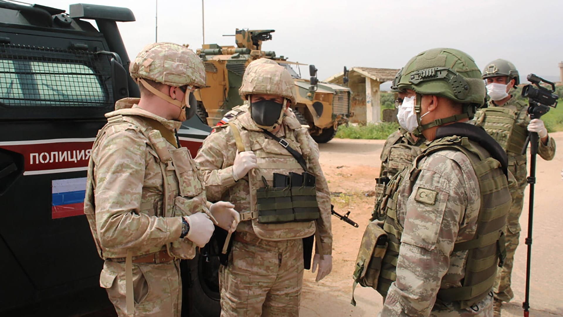 Russische und türkische Soldaten patrouillieren in der syrischen Provinz Idlib mit Schutzmasken.