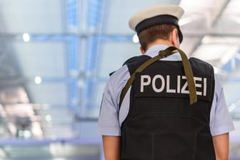 Ein Polizist am Flughafen München (Symbolbild): An Knotenpunkten wie Flughäfen verbreitet sich das Coronavirus besonders leicht.