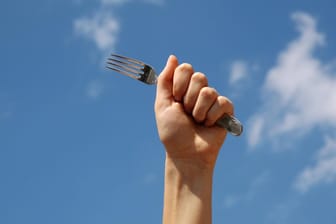 Faust mit einer Gabel vor blauem Himmel: In Hagen sind Polizisten mit Besteck angegriffen worden.