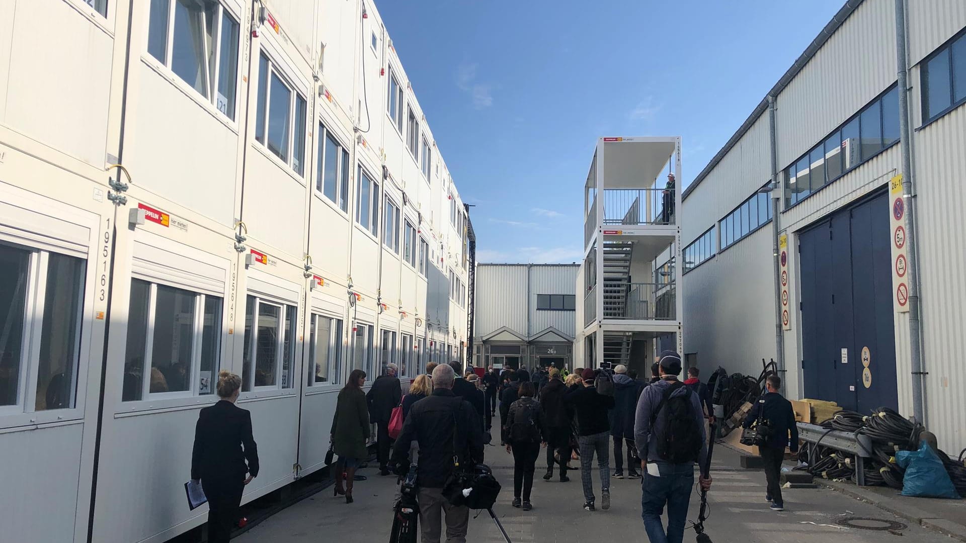 Links sollen die Mitarbeiter sich zurückziehen können, die Treppe rechts soll noch über eine Brücke mit den Containern verbunden werden. In der Mitte hinten befindet sich der Eingang in das Behandlungszentrum. Die Halle rechts gehört dazu. Das wird Berlins Corona-Krankenhaus auf dem Messegelände.