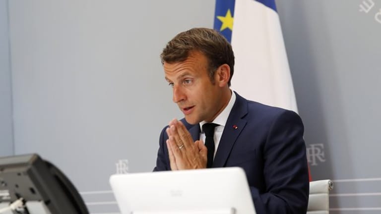 Emmanuel Macron nimmt aus dem Elysee-Palast heraus gestenreich an der WHO-Videokonferenz teil.