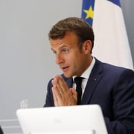 Emmanuel Macron nimmt aus dem Elysee-Palast heraus gestenreich an der WHO-Videokonferenz teil.