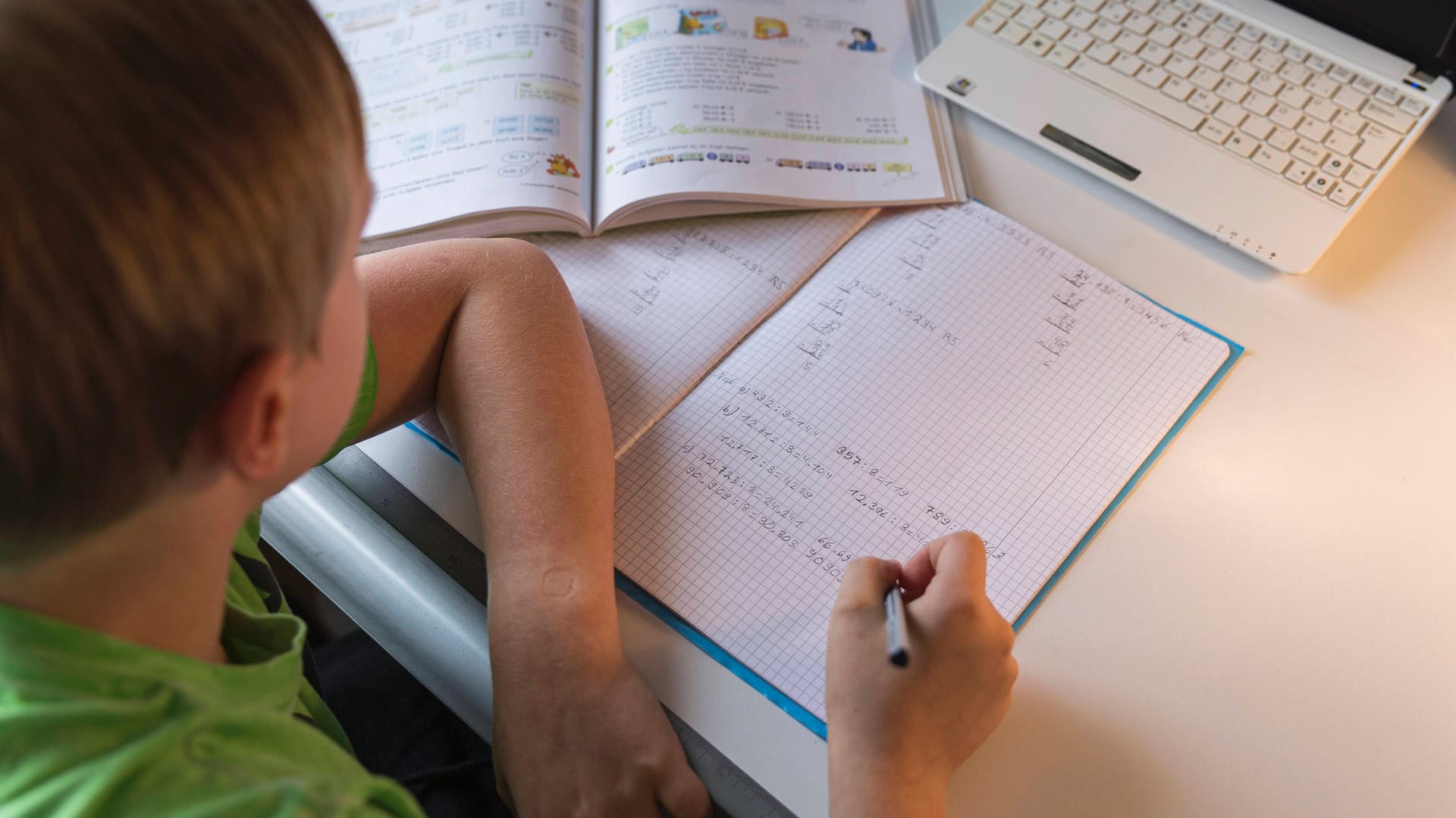 Ein Schüler sitzt vor Schulaufgaben (Symbolbild): In Berlin dürfen Schulen die Zahl der Klassenarbeiten reduzieren.