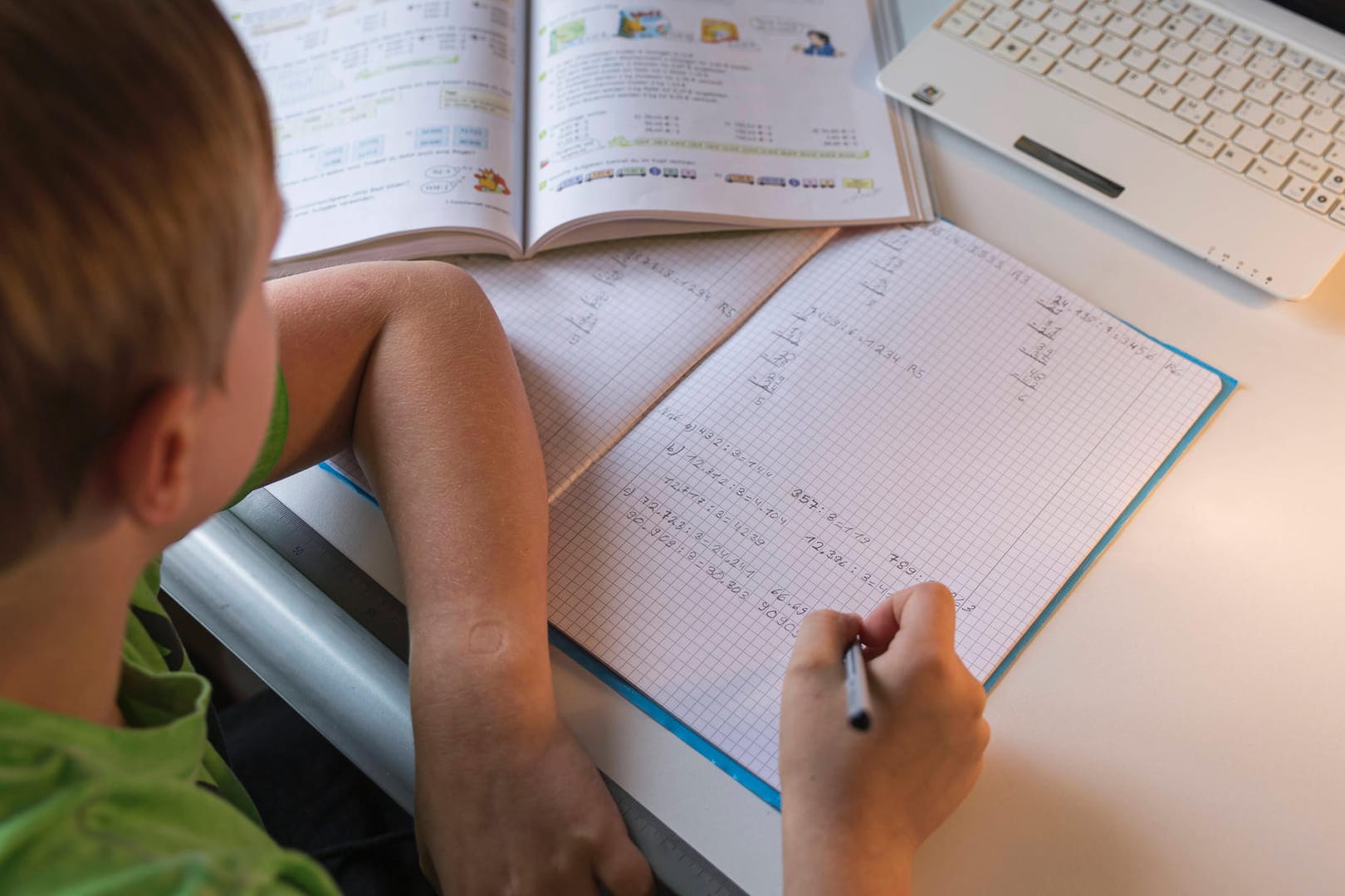 Ein Schüler sitzt vor Schulaufgaben (Symbolbild): In Berlin dürfen Schulen die Zahl der Klassenarbeiten reduzieren.