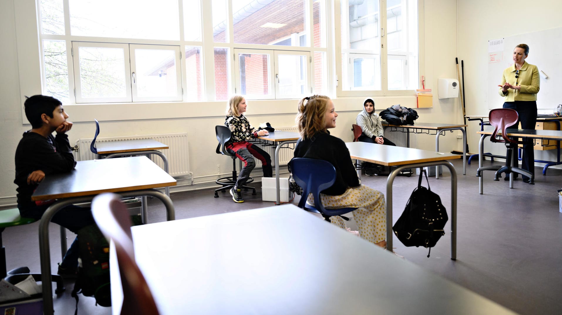 Wiedereröffnung: Dänemarks Ministerpräsidentin Frederiksen (r.) spricht zu Schülern der Lykkebo-Schule in Kopenhagen.