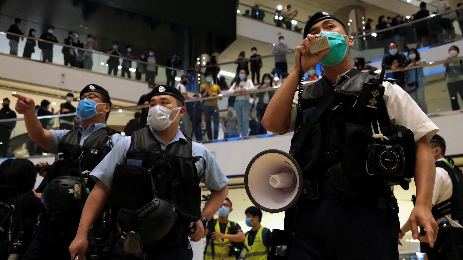 Hongkonger Polizeibeamte mit Schutzmasken: In einem Einkaufszentrum in Hongkong haben trotz strenger Abstandsregeln Hunderte gegen die Regierung protestiert.