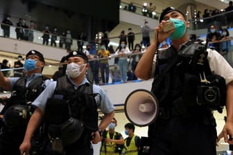 Hongkonger Polizeibeamte mit Schutzmasken: In einem Einkaufszentrum in Hongkong haben trotz strenger Abstandsregeln Hunderte gegen die Regierung protestiert.