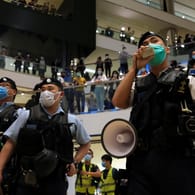 Hongkonger Polizeibeamte mit Schutzmasken: In einem Einkaufszentrum in Hongkong haben trotz strenger Abstandsregeln Hunderte gegen die Regierung protestiert.