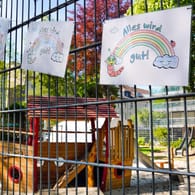 Von Kindern gemaltes Plakat mit der Aufschrift Alles wird gut hängt am Zaun eines Kinderspielplatzes, der wegen der Gefahr vor Ansteckung mit dem Corona-Virus gesperrt ist (Symbolbild).