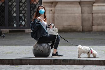 Eine Frau mit ihrem Hund in Rom: In vielen Ländern werden Corona-Maßnahmen vorsichtig gelockert. Ein Ende der Pandemie ist aber nicht in Sicht.