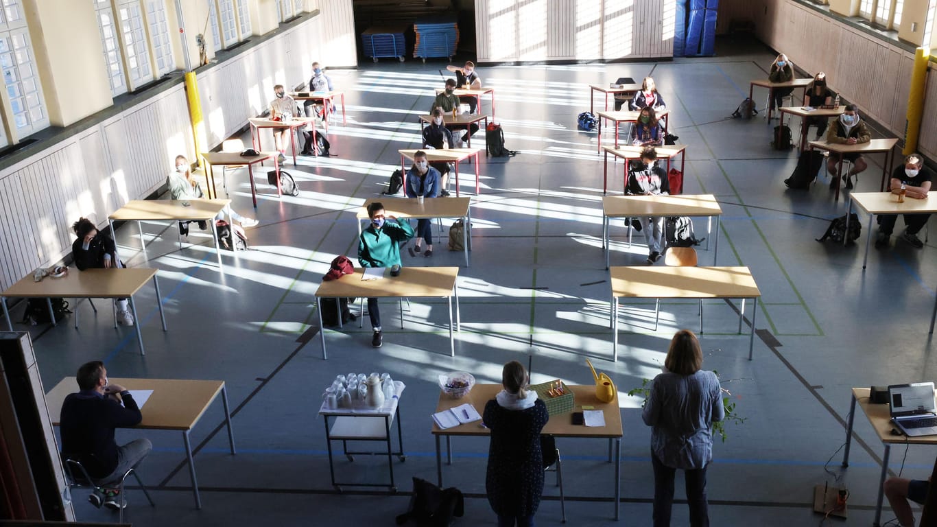Abiturvorbereitungen in Corona-Zeiten: Schüler mit Mundschutz sitzen in einer zum Schulraum umfunktionierten Turnhalle in Jena.