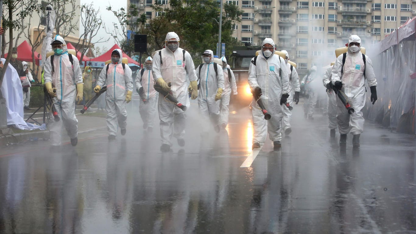 Soldaten der taiwanesischen Armee tragen Schutzanzüge und sprühen Desinfektionsmittel auf eine Straße: Taiwan reagierte umgehend auf den Ausbruch des Virus. (Archivbild)