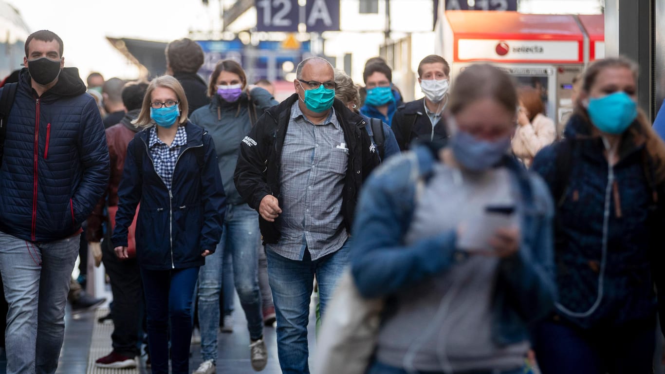 Reisende mit Masken in Frankfurt am Main: Seit Montag gelten in allen Bundesländern Regeln zum Tragen eines Mund-Nase-Schutzes.