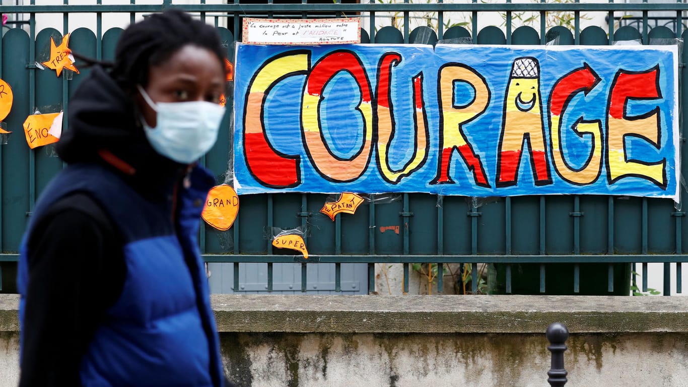 Eine mit Mundschutz maskierte Frau in Paris: Nach Italien wollen auch Frankreich und Italien ihre Corona-Einschränkungen lockern.