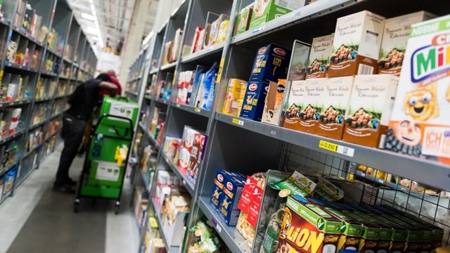 Ein Mitarbeiter des Lebensmittellieferdienstes Amazon Fresh packt bestellte Waren in eine Transporttasche (Archivbild). Ein Mitarbeiter des Lebensmittellieferdienstes Amazon Fresh packt bestellte Waren in eine Transporttasche (Archivbild).