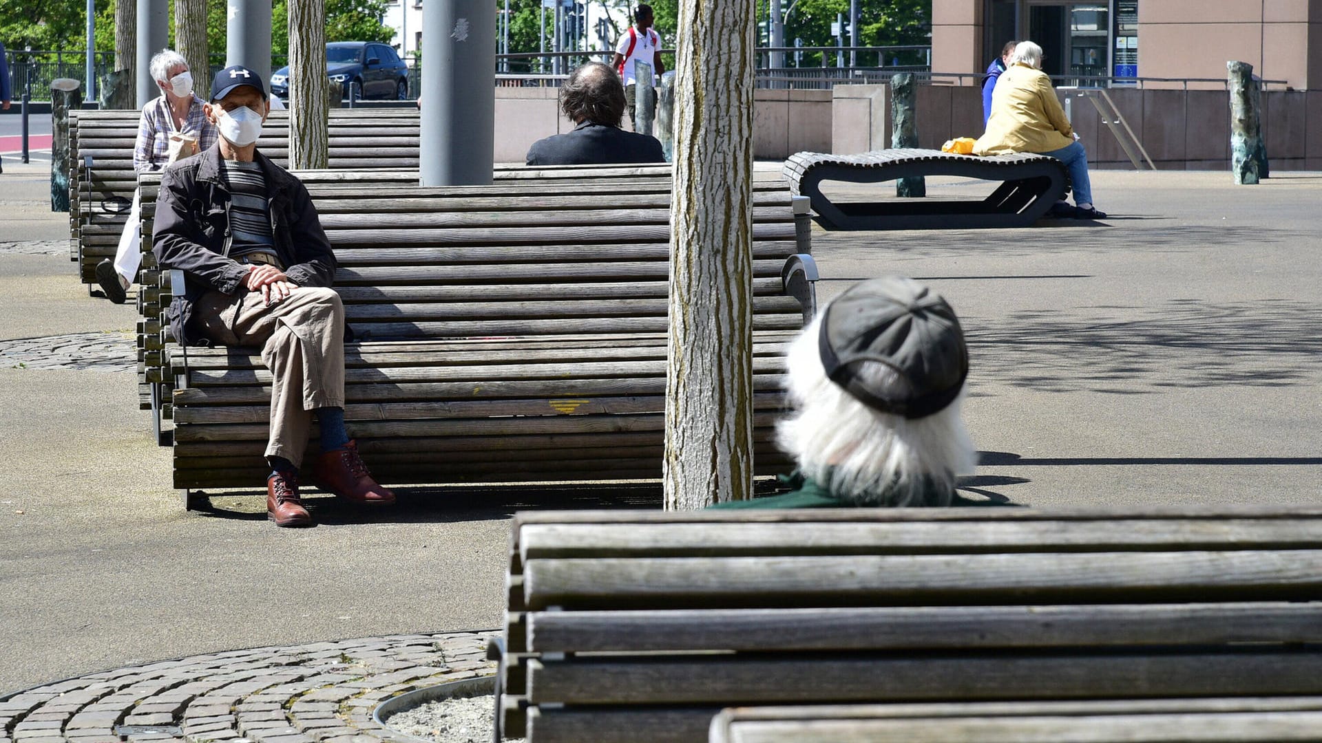 Bürger auf Parkbänken in Saarbrücken: Im Saarland gelten mit die strengsten Regeln wegen des Coronavirus.