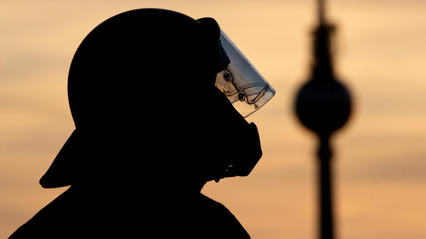 Die Silhouette eines Polizisten ist vor dem Abendhimmel zu sehen: In Berlin sollen am 1. Mai trotz Verboten Demos stattfinden.
