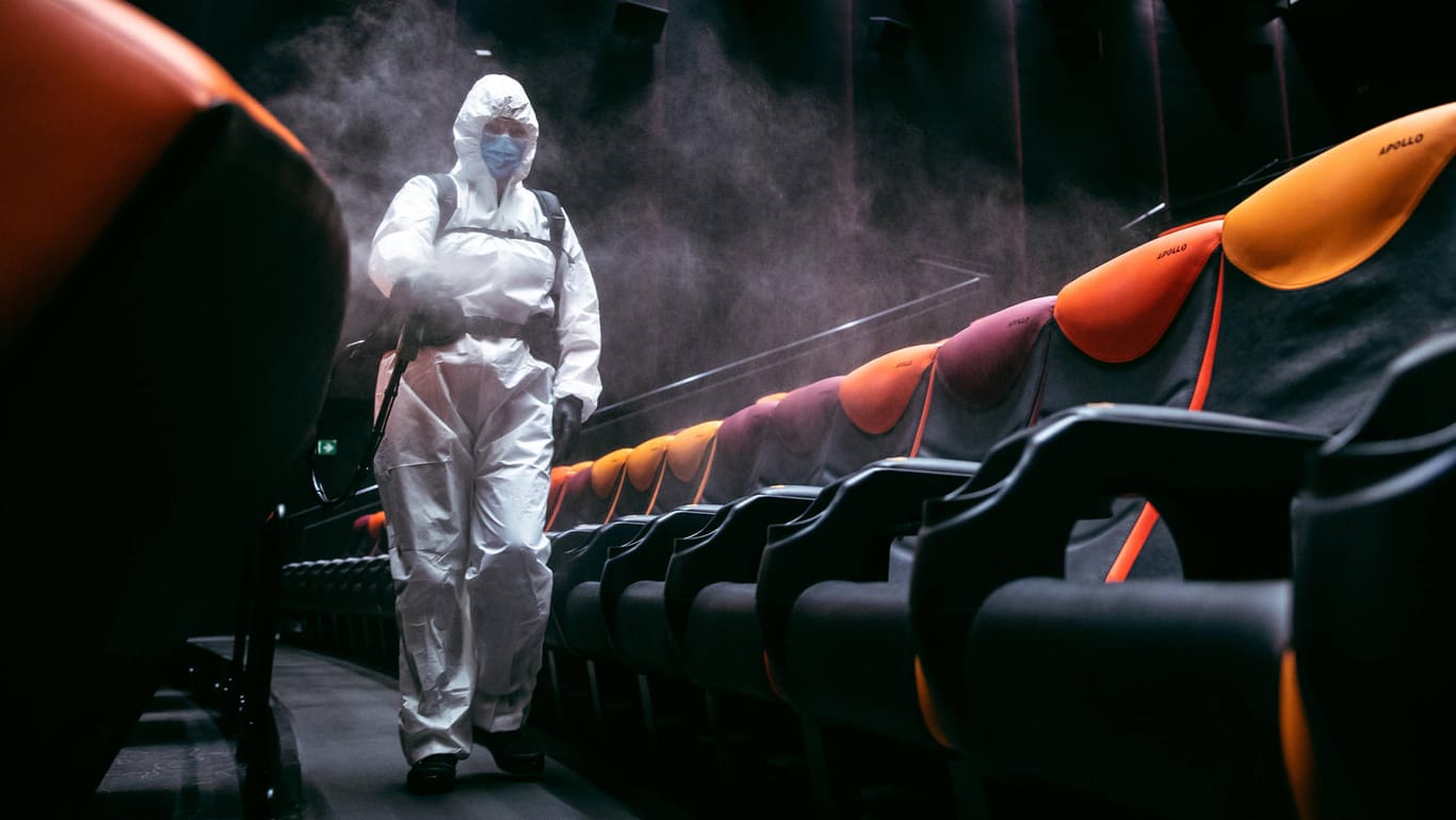 Kinos in der Krise: In einem Saal in Tallinn versprühen Mitarbeiter in Schutzanzügen Desinfektionsspray.