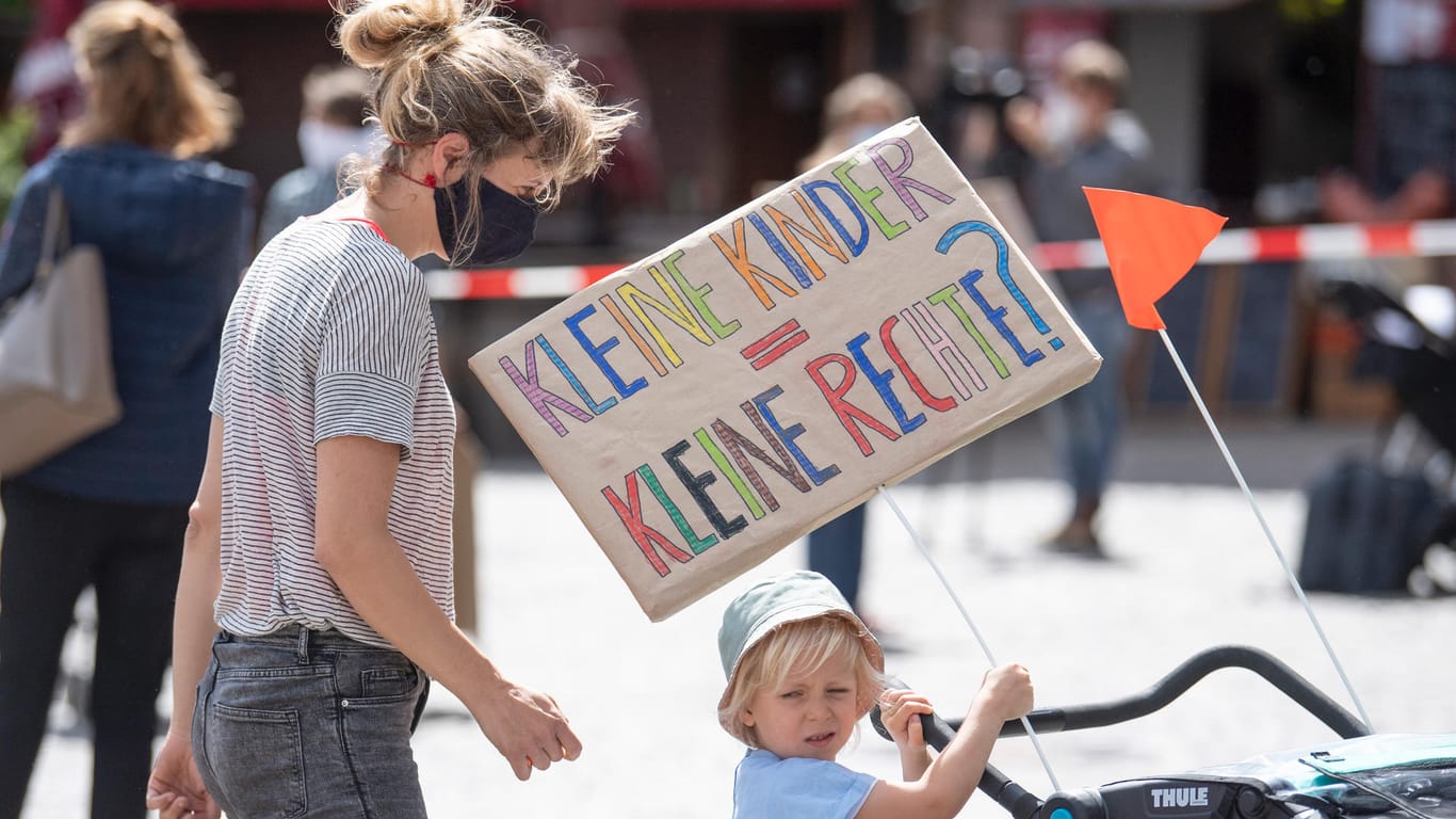 Eine Mutter demonstriert mit ihrem Kind in Frankfurt/Main für die Beachtung der Kinderrechte während der Corona-Pandemie.