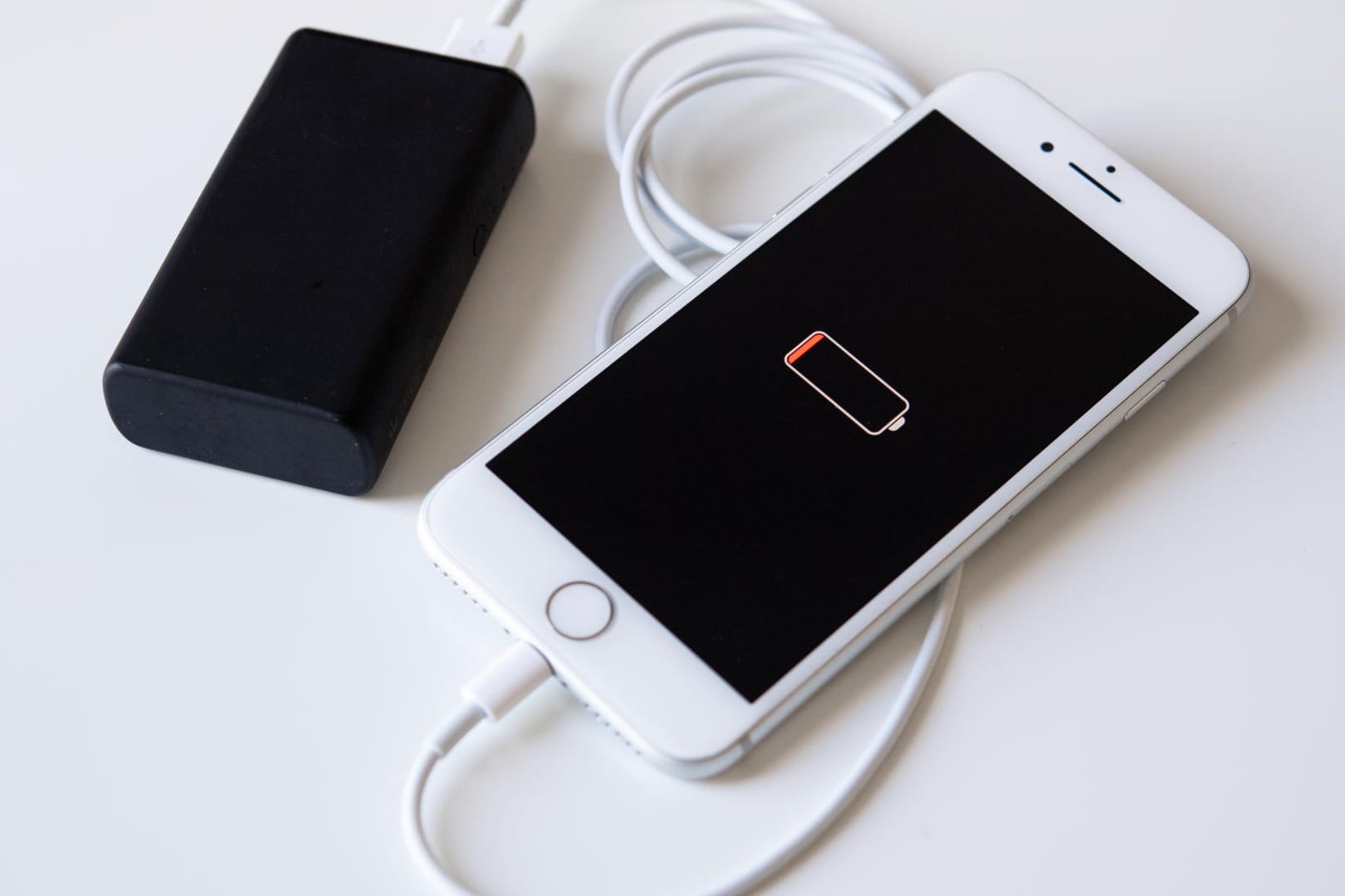 Ein Smartphone und eine Powerbank: Meist haben Powerbanks so viel Saft, dass sich ein Smartphone gleich zwei Mal damit laden lässt.