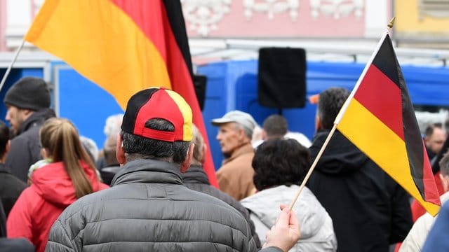 Teilnehmer einer Kundgebung stehen auf einem Platz (Symbolbild): Die Stadt Erfurt hat eine Demonstration der Thüringer AfD zum 1. Mai untersagt.