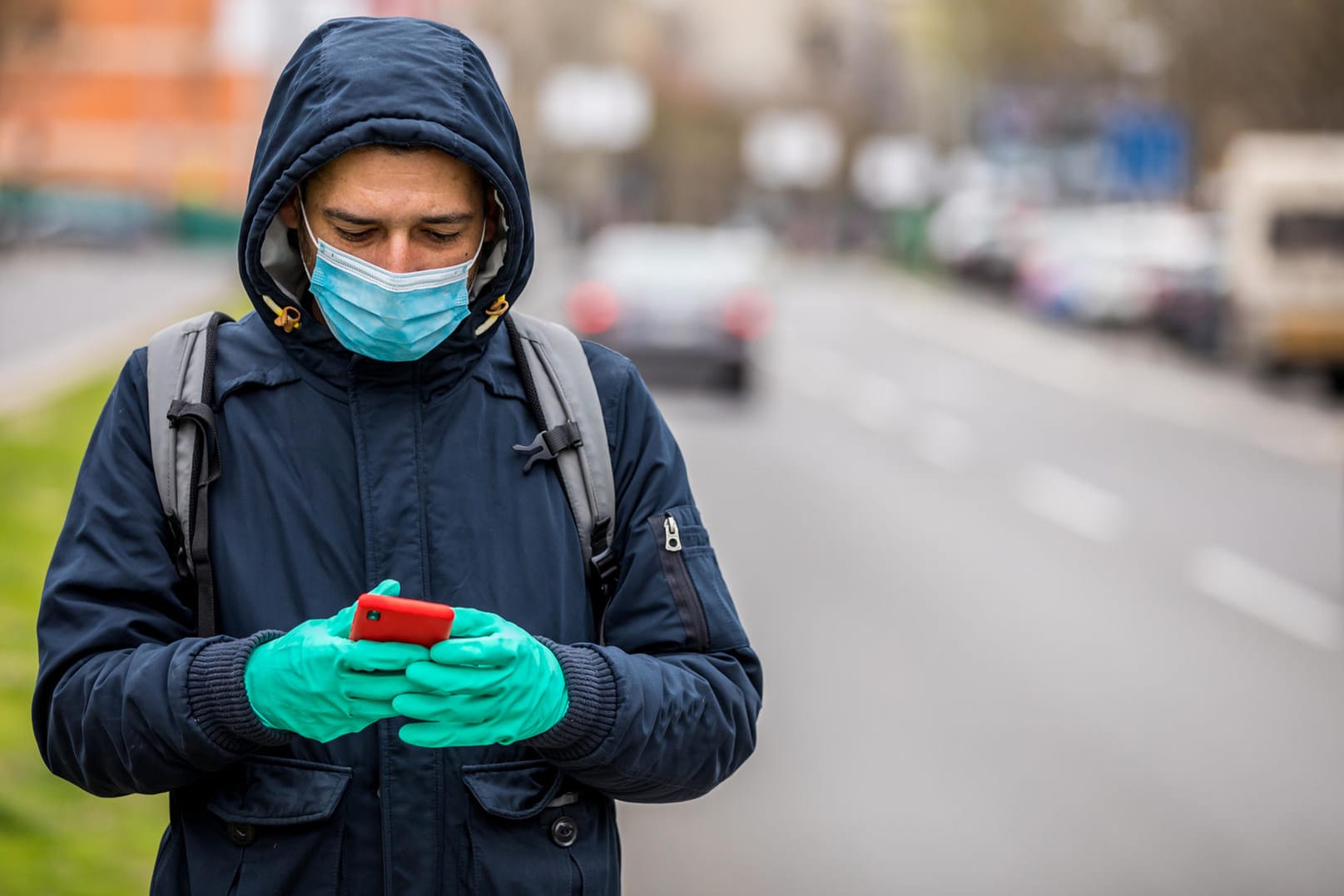Ein Mann mit Maske und Smartphone: Apple und Google arbeiten an einem Konzept für eine Corona-Warn-App.