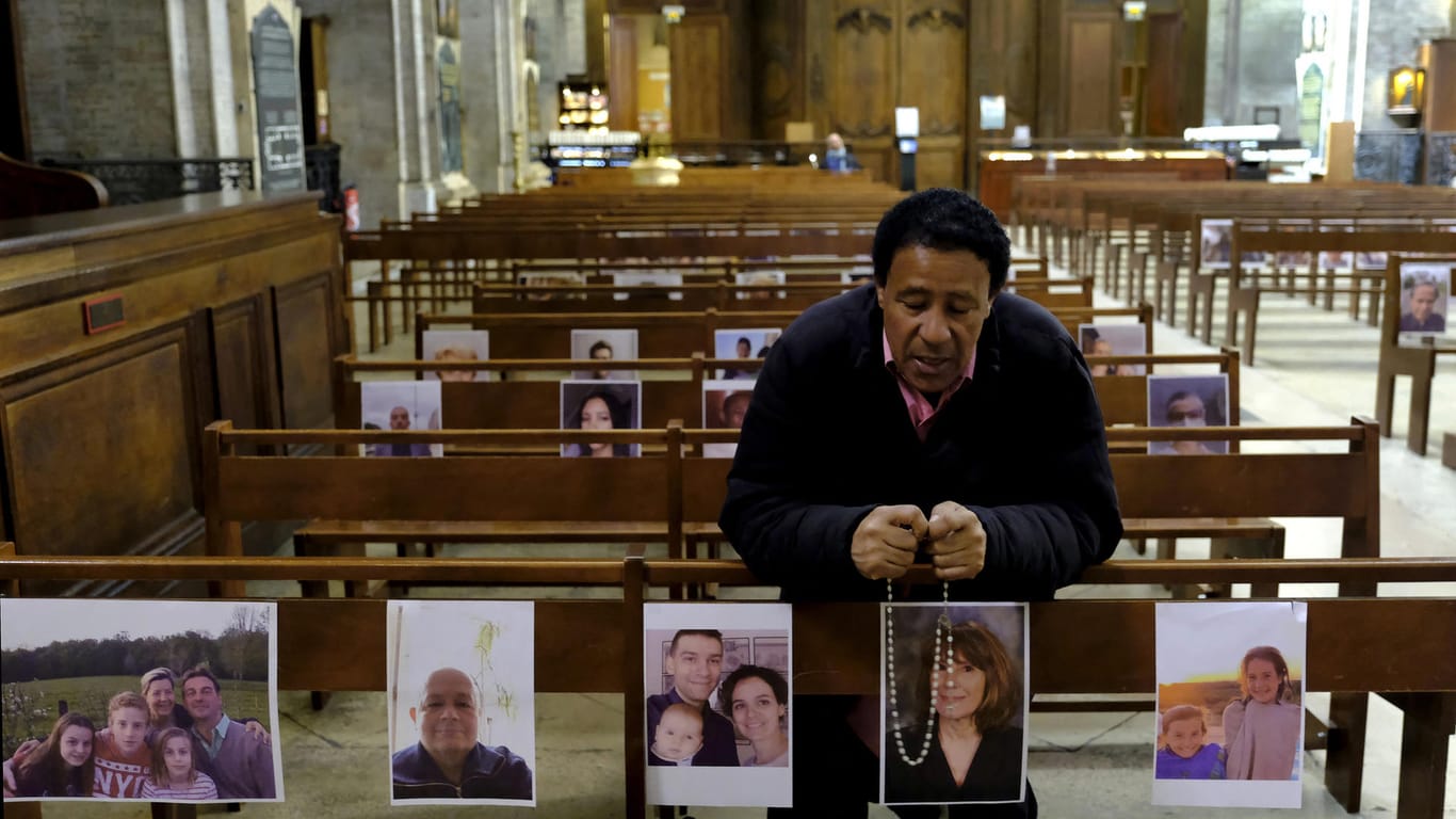 Ein Mann betet in einer Kirche. An die Bänke sind Fotos geklebt: Auch in Frankreich dürfen wegen der Corona-Krise keine religiösen Veranstaltungen stattfinden.