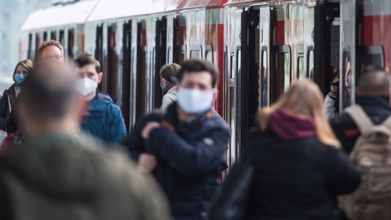 Fahrgäste mit Mund-Nasen-Schutz in einem S-Bahnhof in Hamburg.