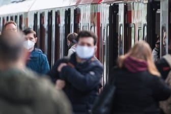 Fahrgäste mit Mund-Nasen-Schutz in einem S-Bahnhof in Hamburg.